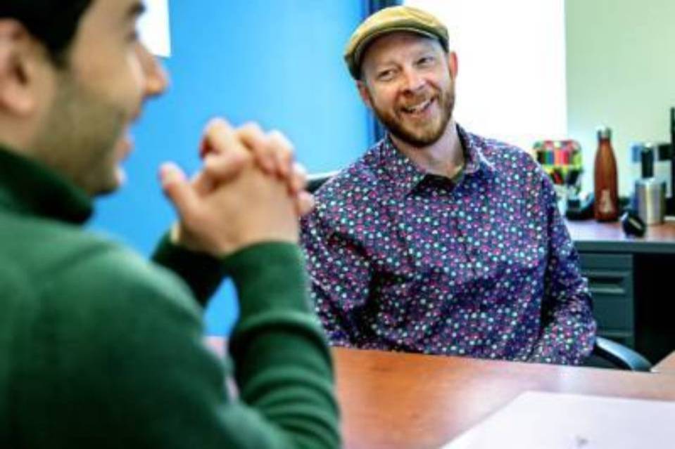 advisor and student sit at a table
