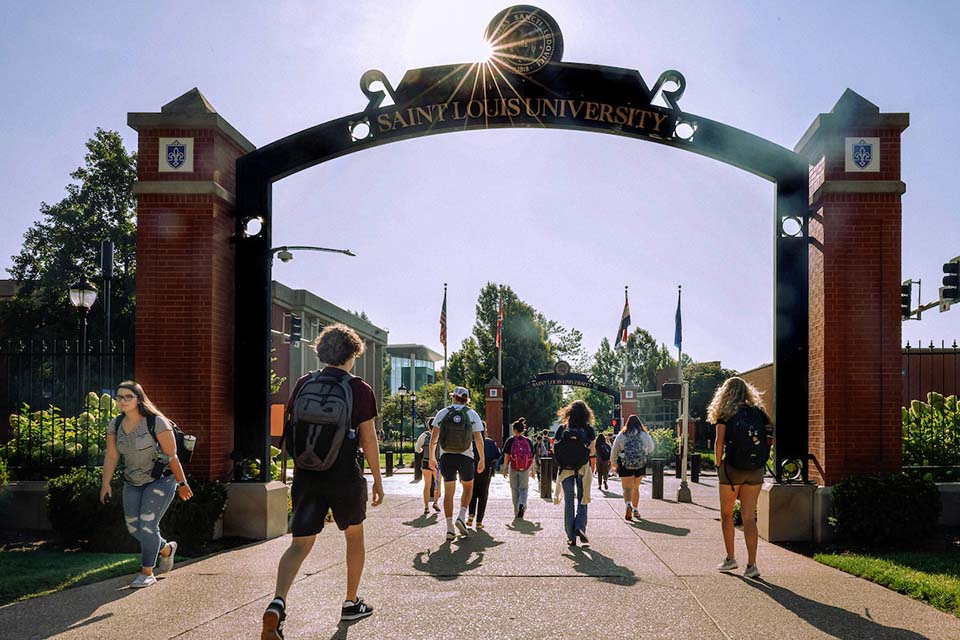 Students walk under an archway on campus.