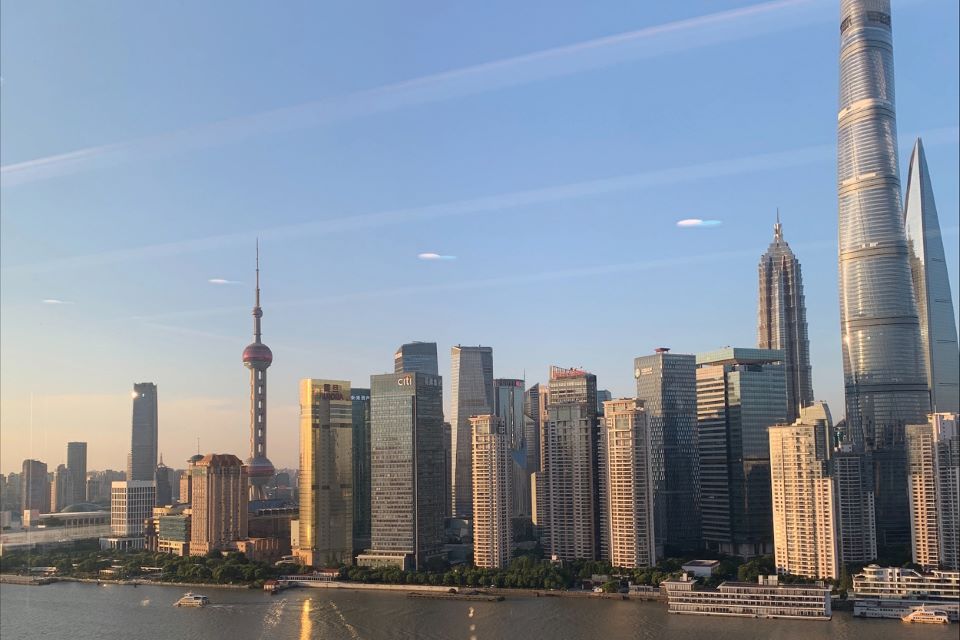 an image of the skyline of Shanghai China with a mix of skyscrapers and lower buildings with a body of water in the foreground Shanghai Skyline