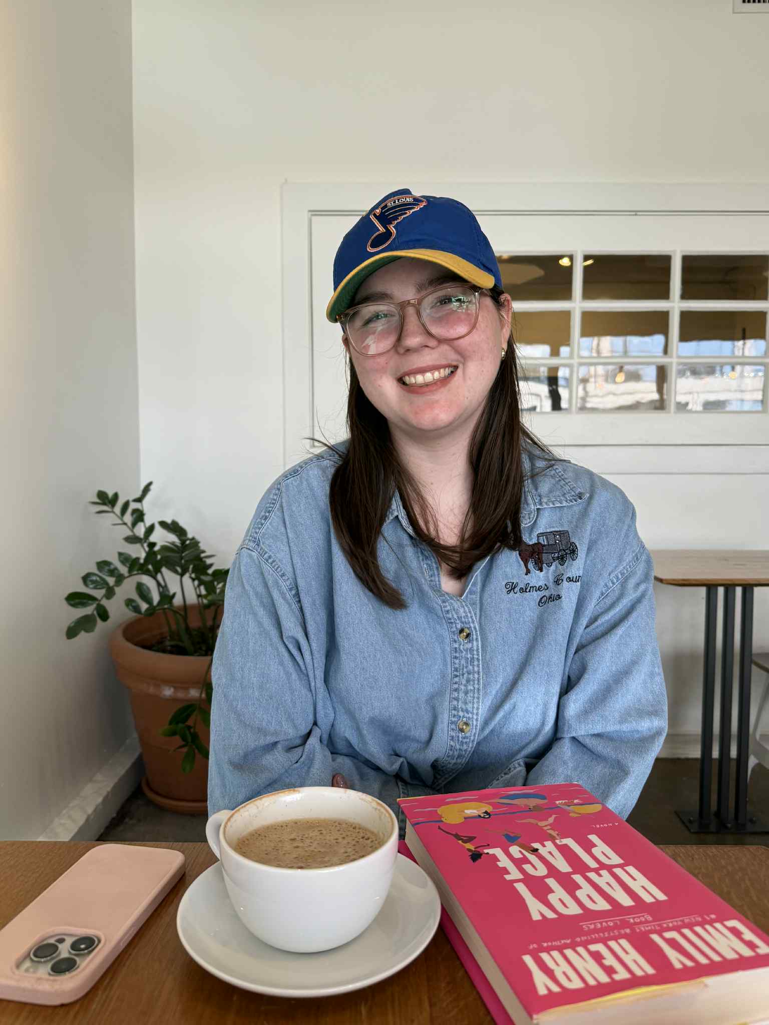 young woman, dark hair wearing a hat at a coffee shop