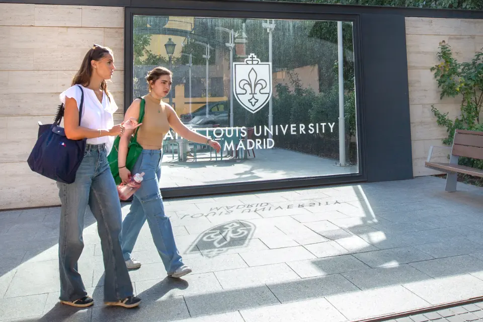 Two students walking outside a building.