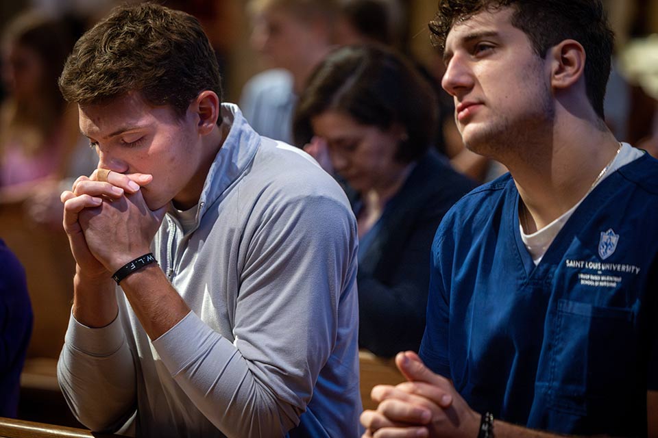 Two men praying at Mass