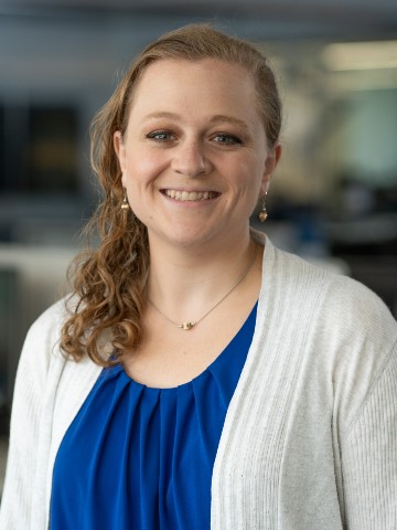 Young woman with blonde hair wearing a white lab coat