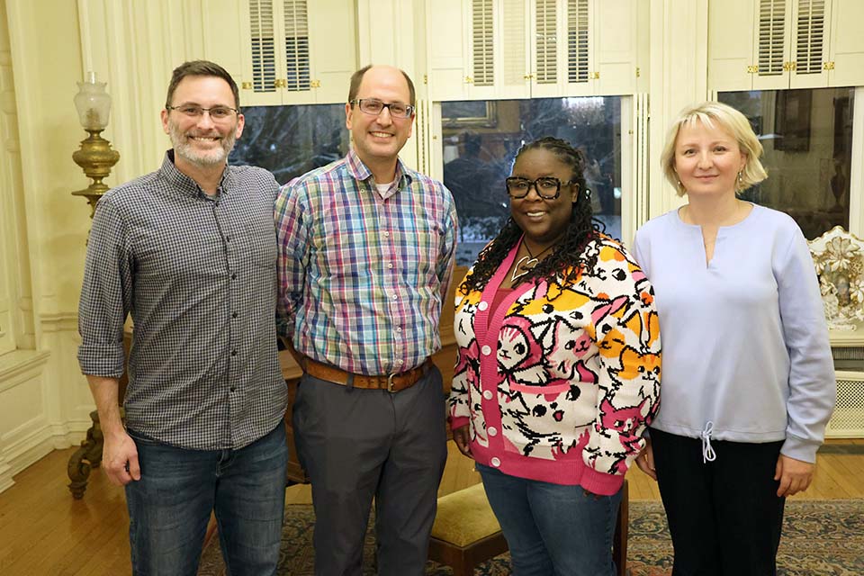 four people pose for a photo