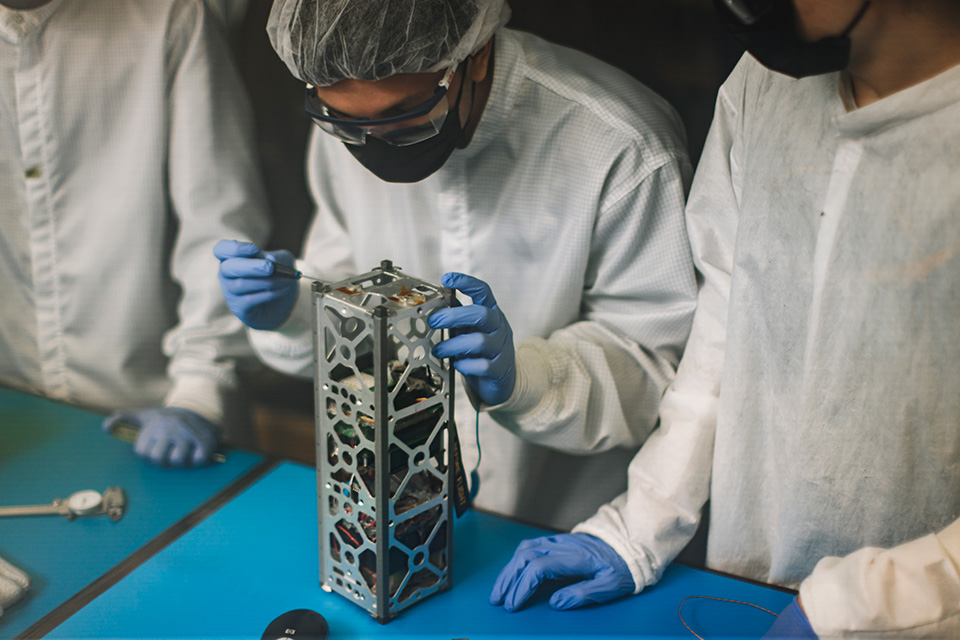 A student working on a satellite in the SSRL.