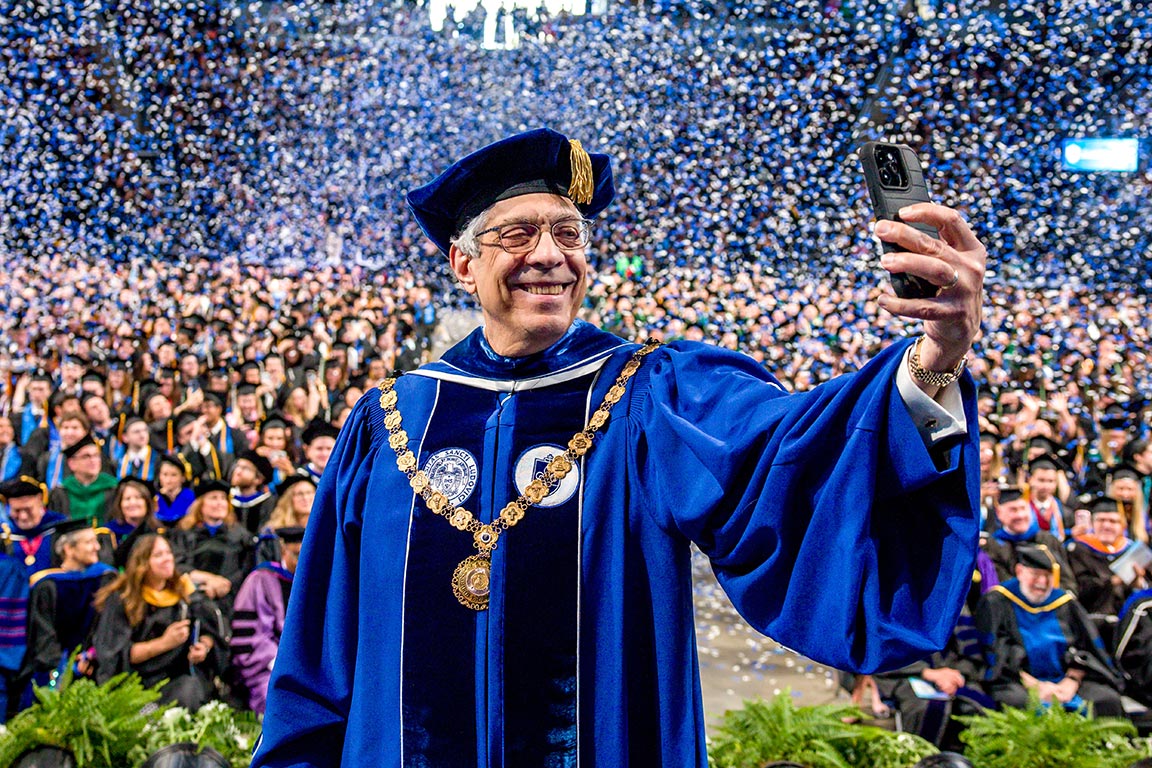 SLU President Pestello takes a selfie as confetti falls on the crowd during the 2025 commencement.
